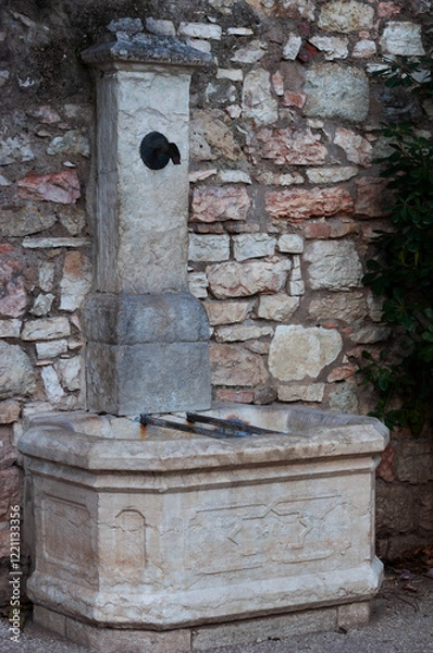 Fototapeta vintage fountain with drinking water in a public park in Italy