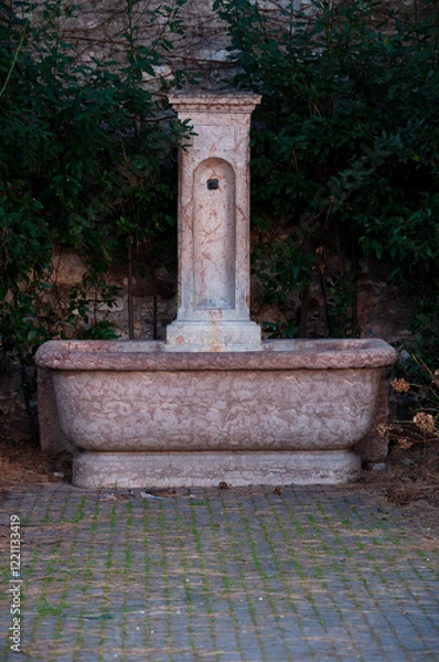 Fototapeta vintage fountain with drinking water in a public park in Italy