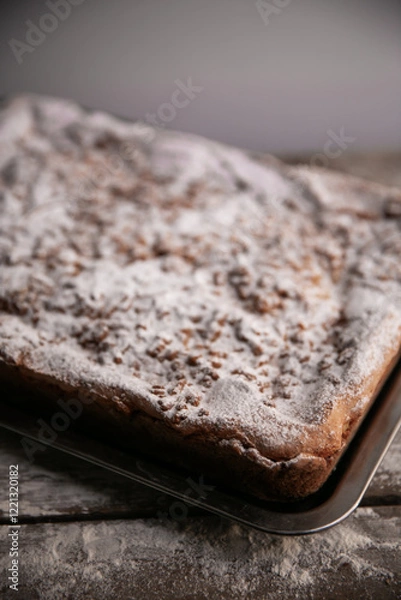 Fototapeta delicious crumble cheesecake from the tin with powder sugar texturetop view