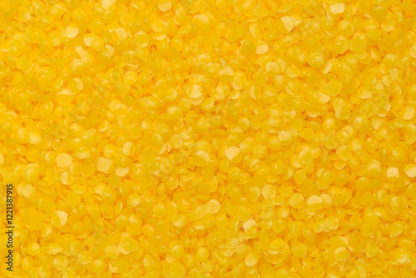 Fototapeta Top view of yellow beeswax pellets, ideal for candle making or crafting. Smooth texture, wax background.
