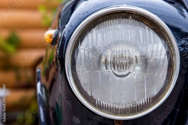 Fototapeta Retro headlight of vintage car. Image with vintage filter. Blurred background