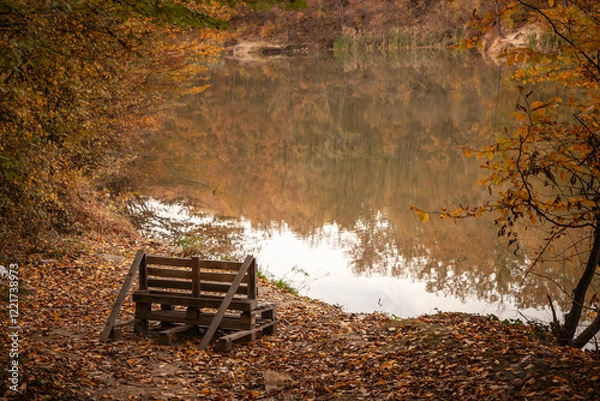 Fototapeta A rustic bench built from wooden pallets sits by the calm lake amid autumn leaves in jezero bela reka, or lake bela reka, in serbia. Its handcrafted style invite visitors to admire the scenic waters.