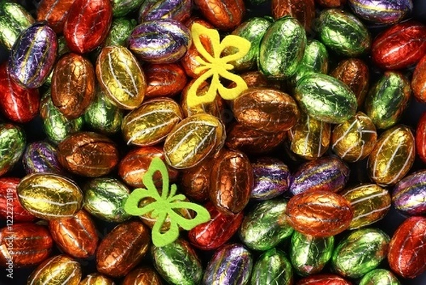 Obraz Chocolate Easter eggs in foil with two felt butterfies. A treat for the Easter holidays.