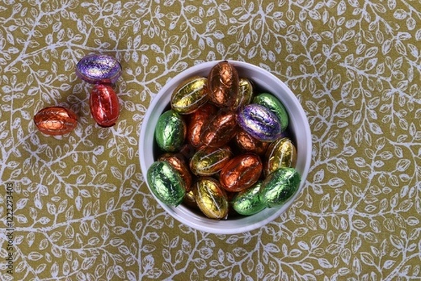 Obraz Chocolate Easter eggs in foil in a white bowl, a treat for the Easter holidays.