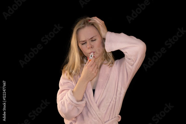 Fototapeta Girl Feeling Sick with Thermometer in Mouth and Headache in Pink Bathrobe