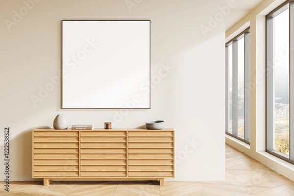 Fototapeta Blank framed canvas on a beige wall above a wooden sideboard in a modern interior room with natural light from large windows. 3D Rendering