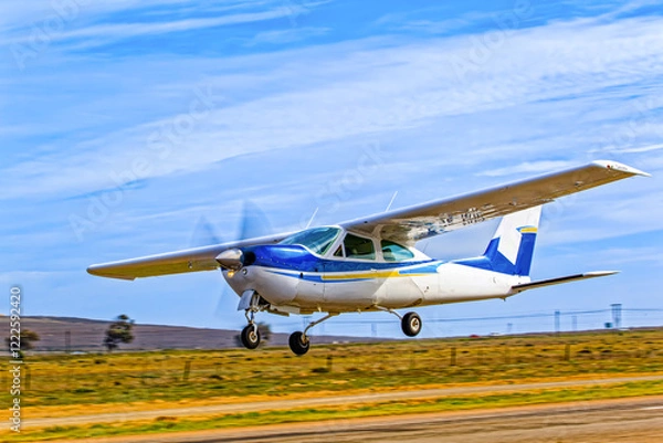 Obraz Sleek single engine, high wing, blue and white aircraft taking off from an airstrip in the Western Cape, South Africa
