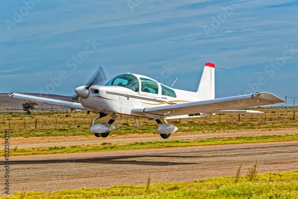 Fototapeta Powerful white and brown, low wing, single engine aircraft taking off from a small airfield in the Western Cape, South Africa