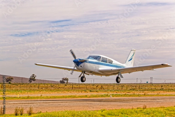 Obraz Classical style blue and white single engine aircraft with four seats taking off from airstrip in the Western Cape, South Africa