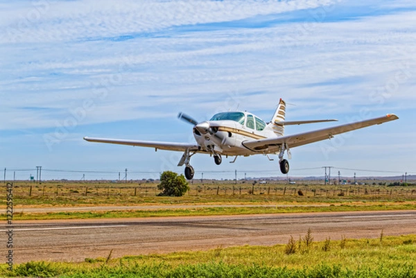 Fototapeta Sleek single engine four seat aircraft with high rear stabilizer and retracting undercarriage taking off from an airstrip in the Western Cape, South Africa