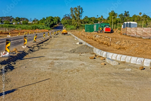 Obraz Road widening activities in a small town in the Little Karoo, Western Cape, South Africa with construction equipment in the background