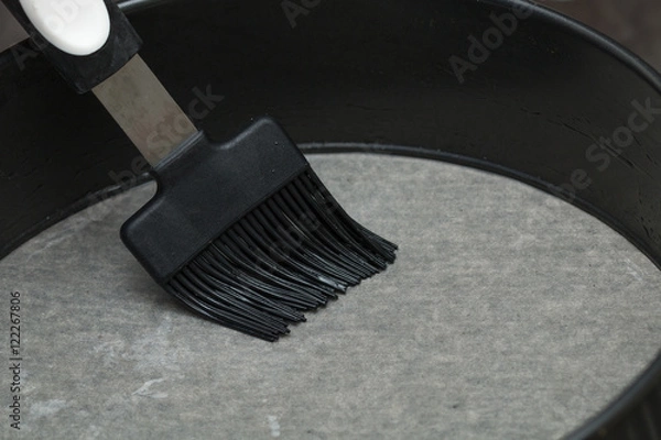 Fototapeta Baking pan grease with a brush.