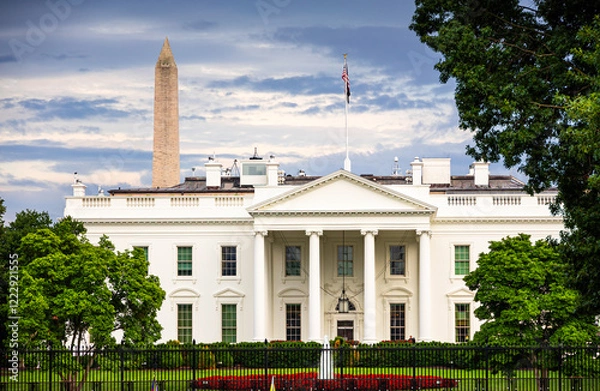 Fototapeta The White House with the Washington Monument in the background, captured on a cloudy day in Washington. A view of iconic American landmarks surrounded by greenery and historical charm. US Presidenct