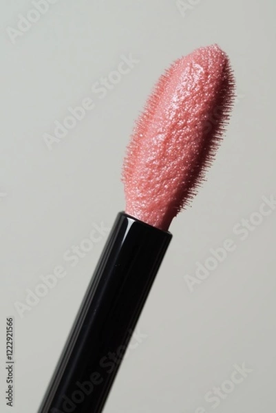 Fototapeta Close-up of a lip gloss applicator with shimmery pink product.