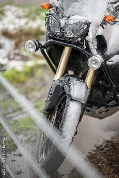 Fototapeta A large black touring motorcycle is covered in snow. The end of the motorcycle season, winter. The inscriptions "Stupid snow, No, WTF" symbolize stubbornness and the desire to continue traveling
