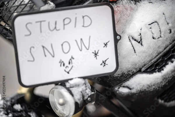 Fototapeta A large black touring motorcycle is covered in snow. The end of the motorcycle season, winter. The inscriptions "Stupid snow, No, WTF" symbolize stubbornness and the desire to continue traveling