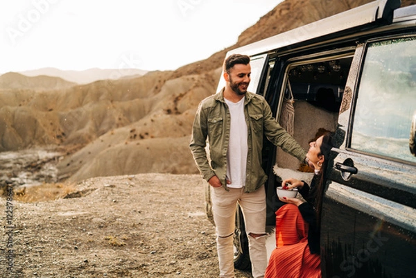 Fototapeta Couple enjoying breakfast in desert by camper van