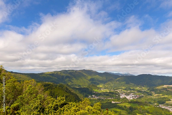 Fototapeta Aerial view of Sao Miguel Island with mountains and small villages, Azores, Portugal. Island landscape in summer when clouds are lifting on the horizon.