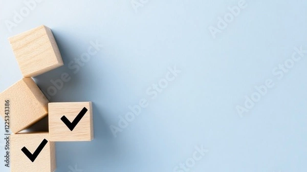 Fototapeta Wooden blocks displaying checkmark symbols are arranged on a soft blue background, providing ample space for adding text or design elements