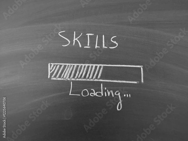 Fototapeta Skills loading shown on blackboard with chalk writing, depicting personal and professional growth and education concept.