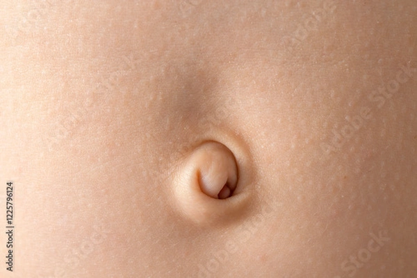 Fototapeta Close-up of a baby navel with delicate skin in soft lighting, highlighting the texture.