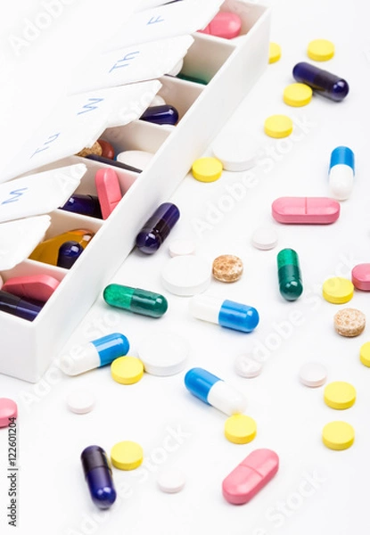 Fototapeta Color pills and capsules in and out of pill organizer