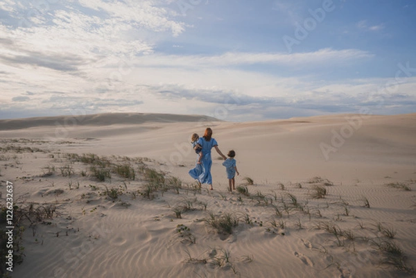Fototapeta Mum on sand dune with children
