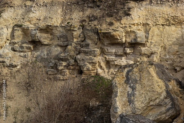 Fototapeta Rock formations on a rugged hillside showcasing natural geological patterns and textures