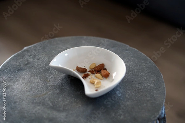 Fototapeta A small bowl containing the rest of various types of nuts.