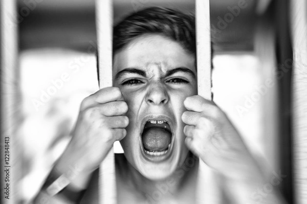 Obraz child shouting behind prison bars - drama style