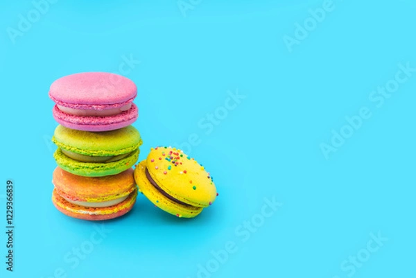 Obraz A few brightly colored stacked macarons on blue background. Mixed of colorful macaroni or pasta cake. Tasty and colorful french macarons. Culinary, cooking concept, styling food. Add your text.