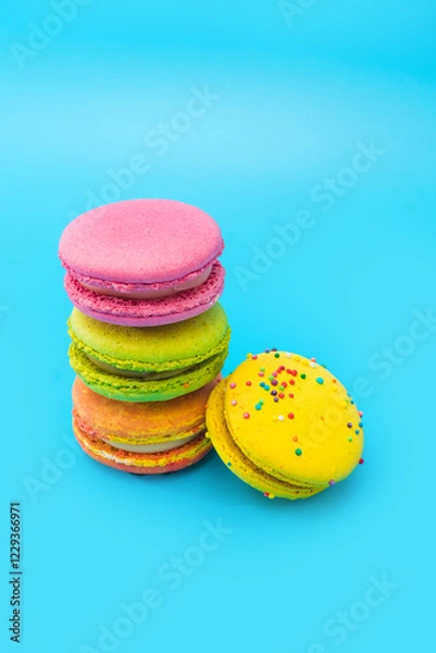 Obraz A few brightly colored stacked macarons on blue background.