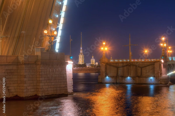 Fototapeta Night view of illuminated Neva River, open Trinity Bridge and Peter and Paul Cathedral between its wings, Saint Petersburg, Russia.