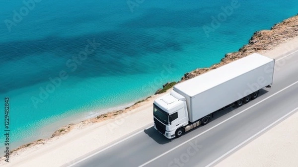 Fototapeta Aerial view of a white truck driving on a coastal road next to clear blue sea on a sunny day, showcasing efficient and scenic transport.