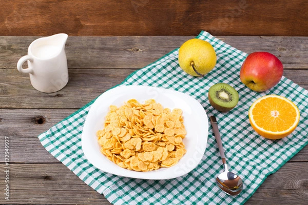 Obraz Breakfast: flakes in a plate, milk in a jug