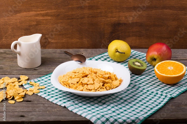 Obraz Breakfast: flakes in a plate, milk in a jug
