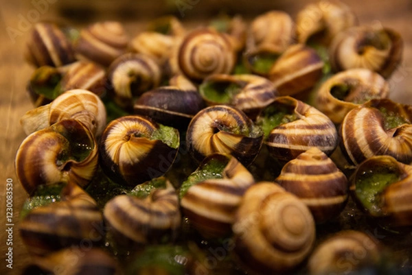 Fototapeta Close up Escargots, baked snails with garlic, butter and basil. French traditional food.