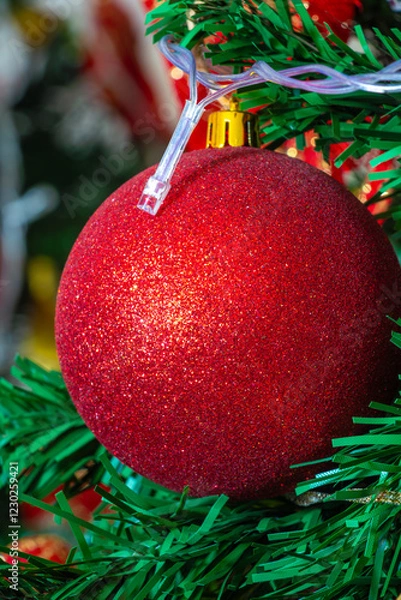 Fototapeta Close up of red balls with glitter decorating green Christmas tree.