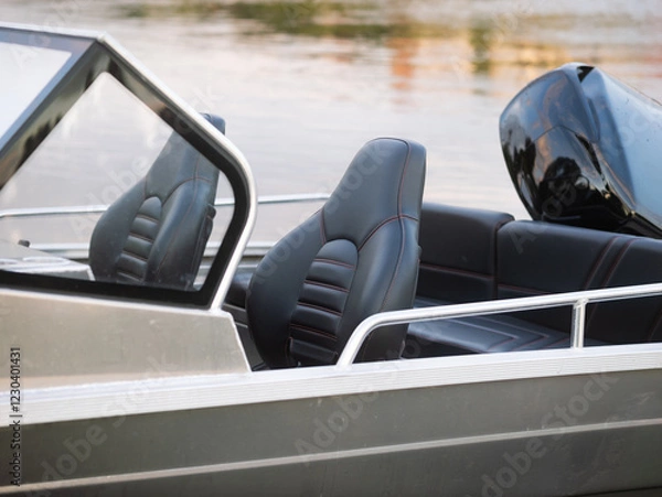 Obraz Sport boat with empty seats close-up. Aluminum vessel in a river or lake. Motor boat with an outboard engine and dark leather interior.