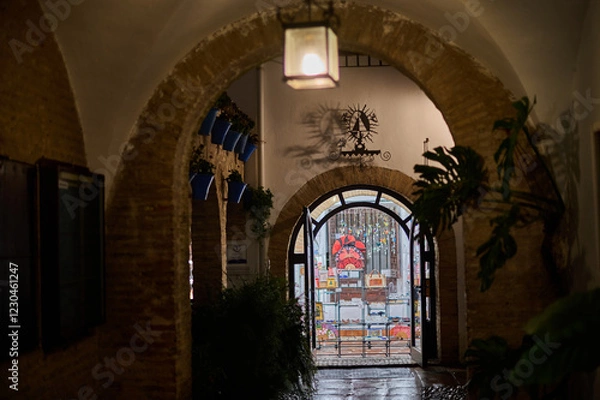 Fototapeta The narrow, whitewashed streets of the Jewish Quarter in Córdoba at night, illuminated by soft lights, showcasing the charm and history of Andalusia, Spain