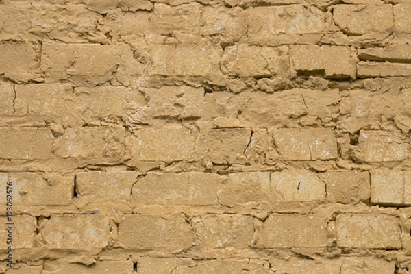 Fototapeta Old worn yellow brick wall background.