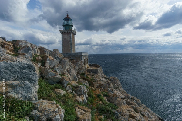 Fototapeta The lighthouse at rocky cape Tainaron on a cloudy spring day, Mani, Peloponnese, Greece.