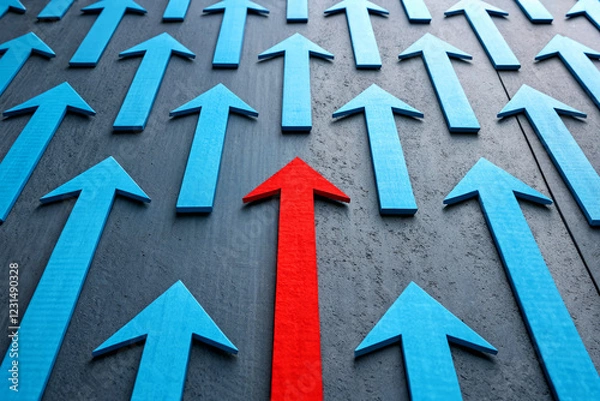 Fototapeta Red Arrow Pointing Up Among Blue Arrows Representing Leadership and Uniqueness in Business