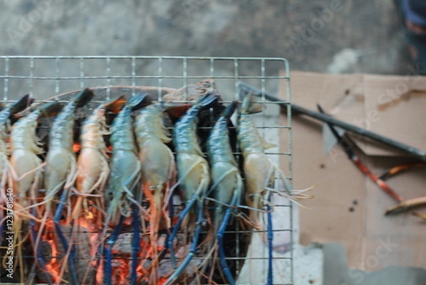 Obraz  Raw Shrimp on Grill with Charcoal Background