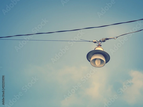 Fototapeta Color filter image/ Old bulb hanging on the sky, Selective focus 