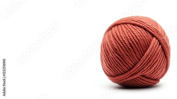 Fototapeta A soft, reddish yarn ball sits on a white background, perfect for knitting or crafting projects.