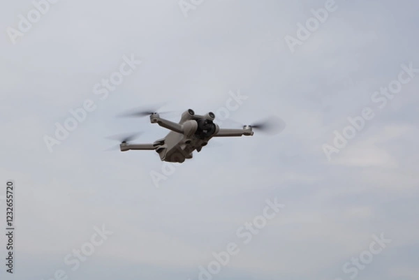 Obraz drone flying in cloudy blue sky, copy space.