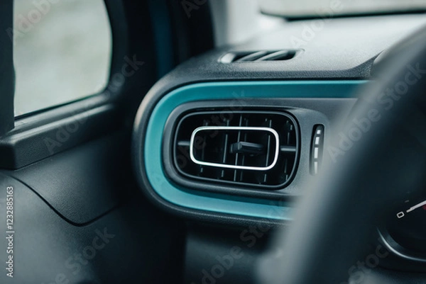 Fototapeta Leftmost A/C vent in car dashboard - deflector of air conditioning system. Car interior with turquoise trim stripe. Modern car with climate control.