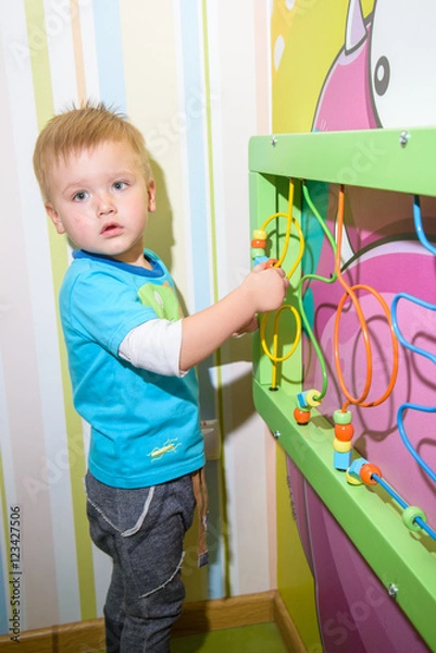 Fototapeta kid playing with developing toys