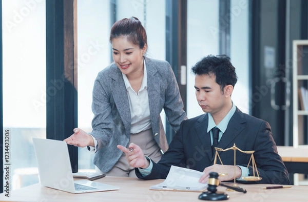 Fototapeta Legal Professionals Consulting: Two legal professionals, a man and a woman, collaborate on a case, reviewing documents and using a laptop in a modern office setting.